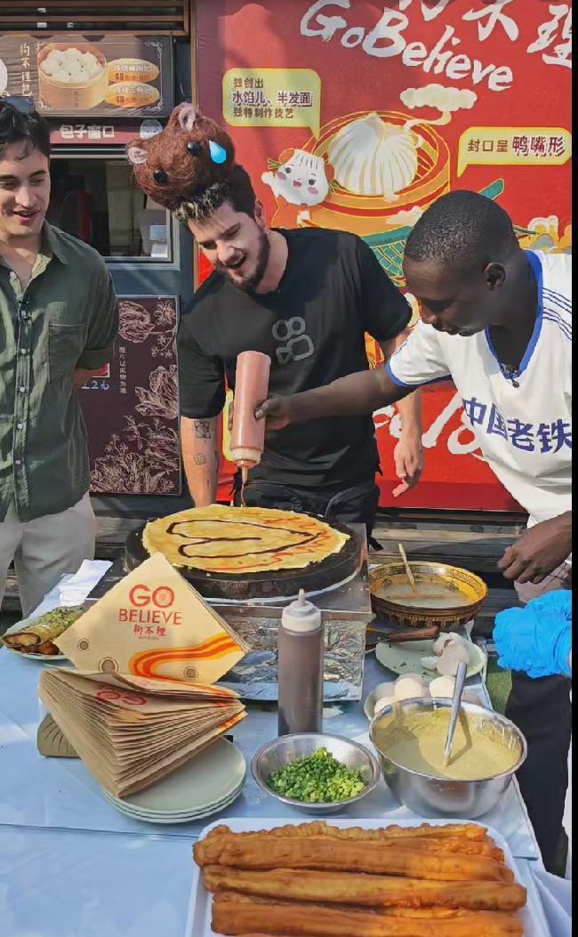 国际网红无语哥天津体验摊煎饼果子学打太极时频现表情包曹云金现场教他打快板